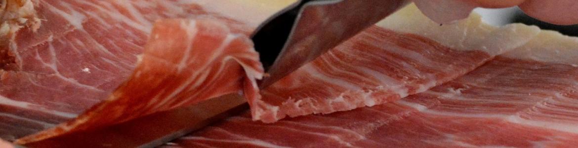 Jamón ibérico Imagen de una persona cortando una pata de jamón ibérico