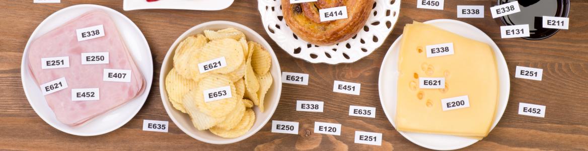 Varios alimentos que tienen identificados en un cartel los aditivos alimentarios que contienen