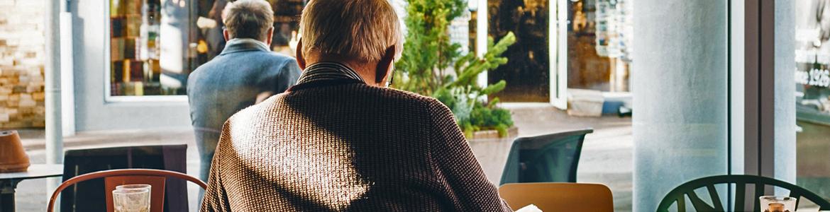 Recurso enlace pensiones no contributivas Persona mayor de espaldas en un café