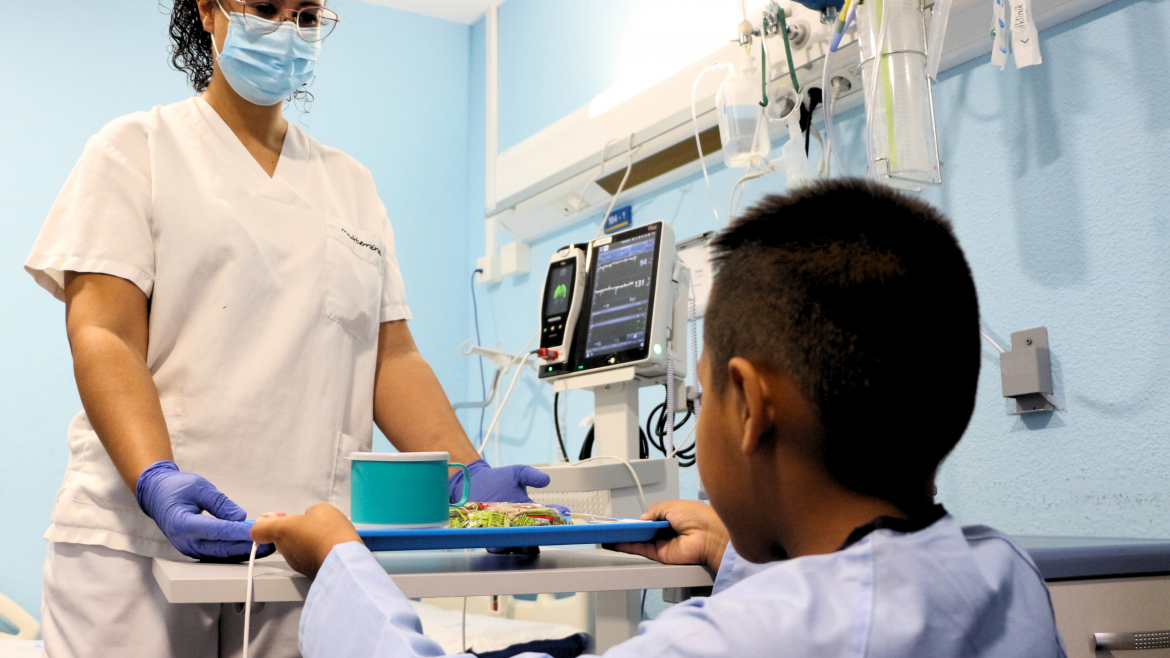 Hospital Severo Ochoa | Carta pediátrica, juegos y felicitación promovido por la comisión de humanización Enfermera repartiendo desayuno a paciente pediátrico