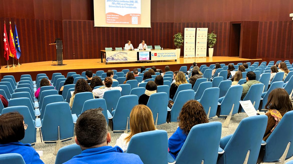Personas sentadas de espaldas en un salón de actos