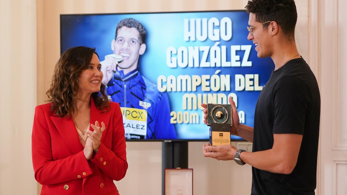 La presidenta le da un trofeo al nadador