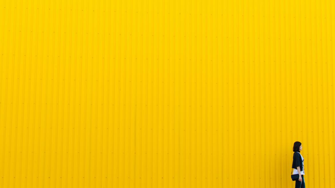 Mujer caminando sobre fondo amarillo Mujer caminando