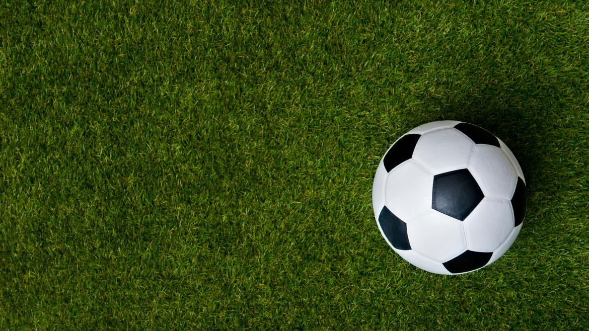 Una pelota de fútbol en el medio de un campo de césped
