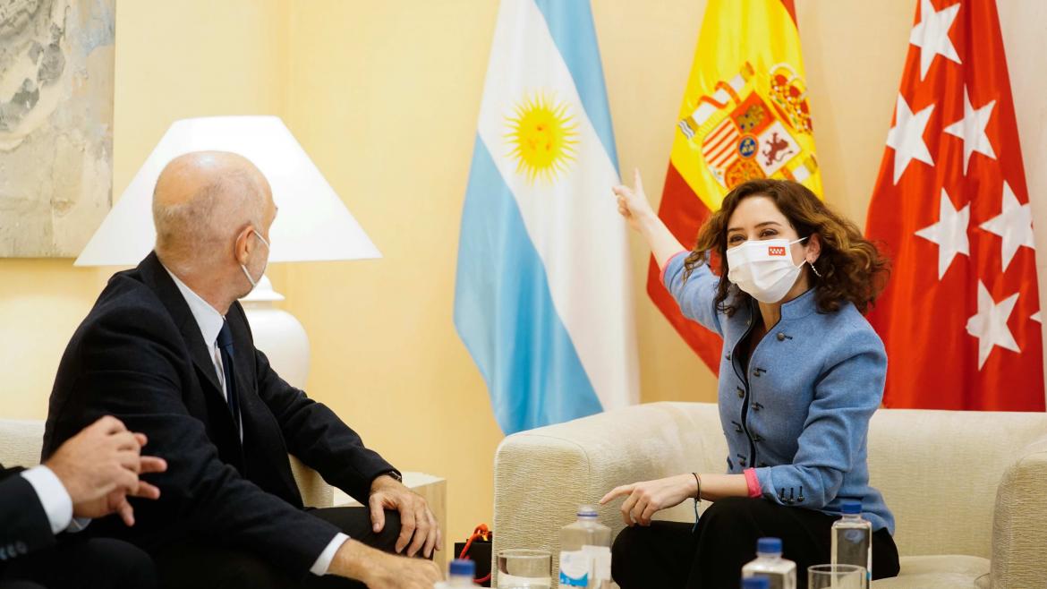 La presidenta sonríe y le señala al jefe de Gobierno la bandera de Argentina