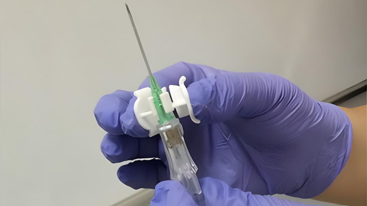 Una mano con guante azul sostiene un dispositivo