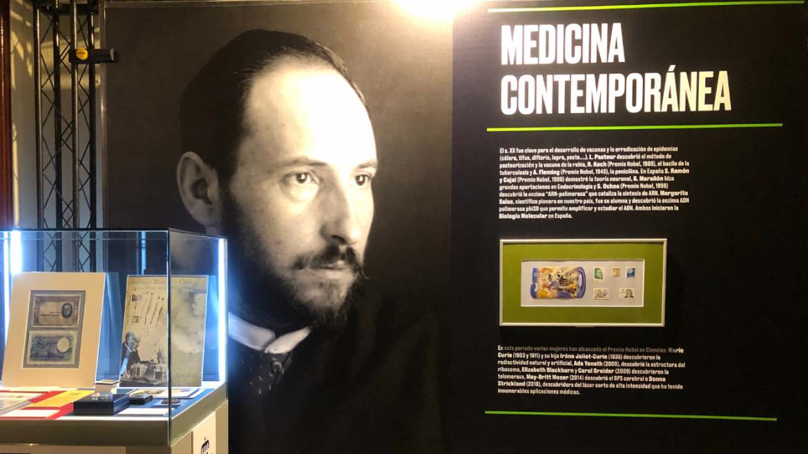exposición con panel al fondo con rostro de hombre de primeros de siglo y a la derecha una vitrina con objetos