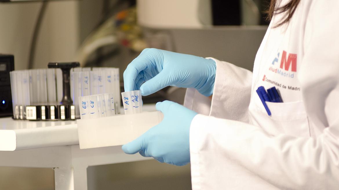 Investigación Unas manos con guantes manejan tubos para investigación