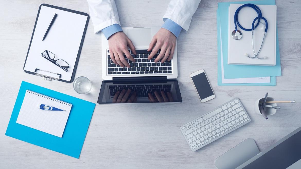 profesional sanitario escribiendo en ordenador portátil