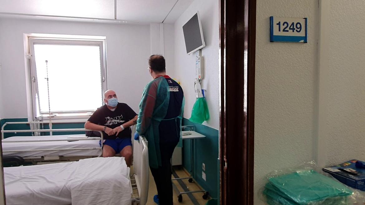 David sentado en la cama y su hermano de pie