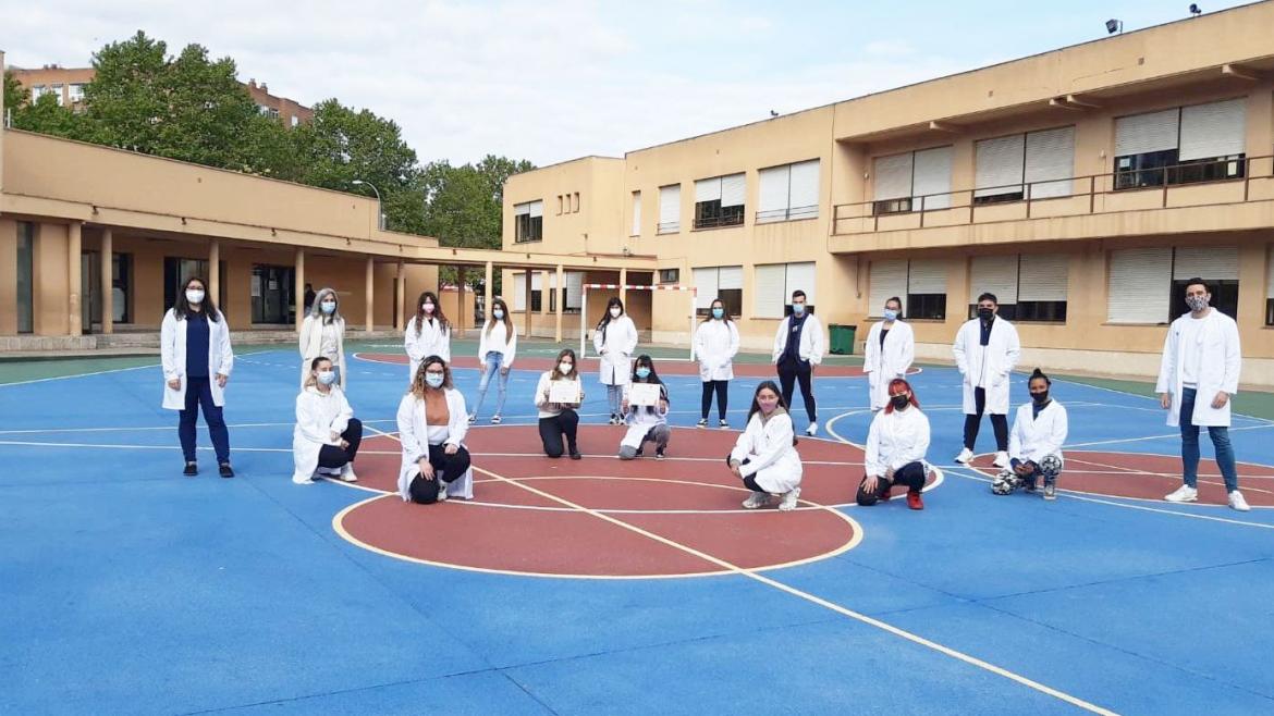 grupo de alumnos separados por distancia de seguridad posando con diploma 