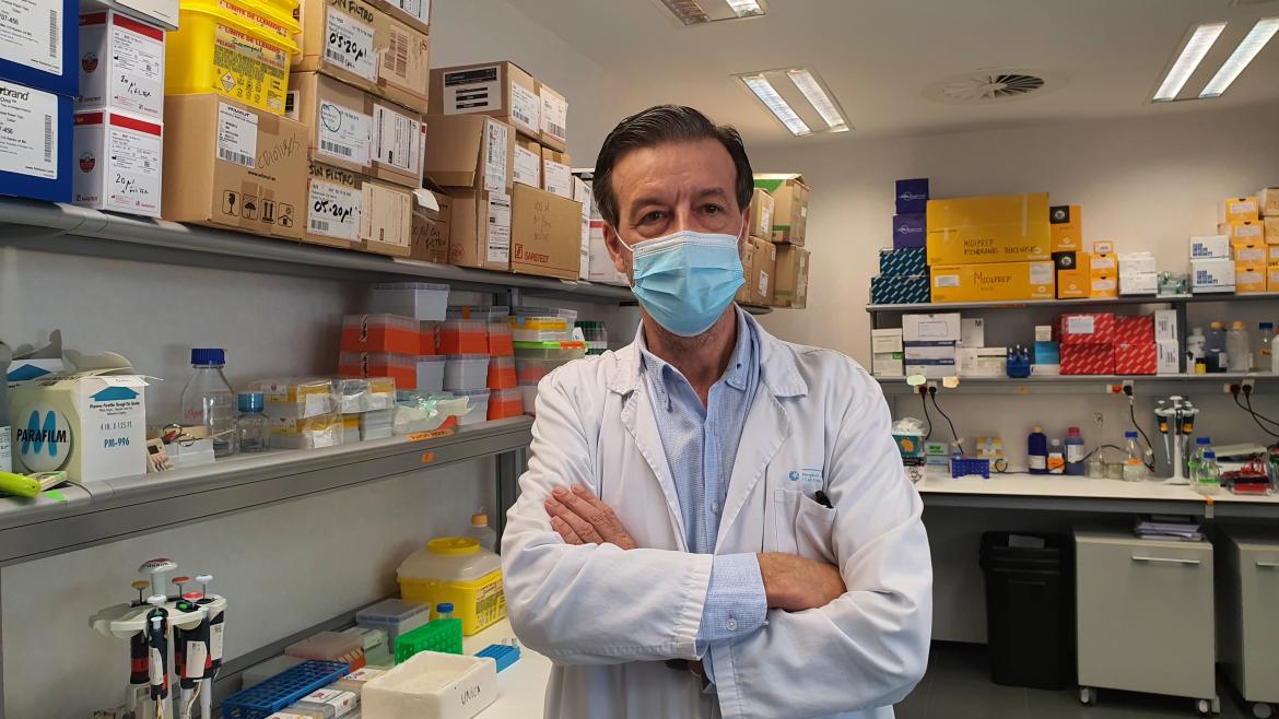 Hombre con bata blanca de facultativo posando en laboratorio