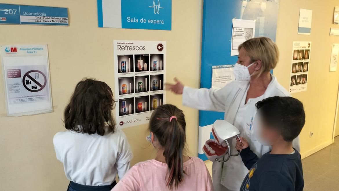 Profesional sanitario dando explicaciones a niños