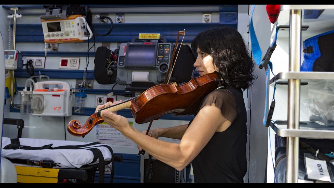 Una violinista de la ORCAM interpreta una pieza musical en el interior de una UVI del SUMMA 112
