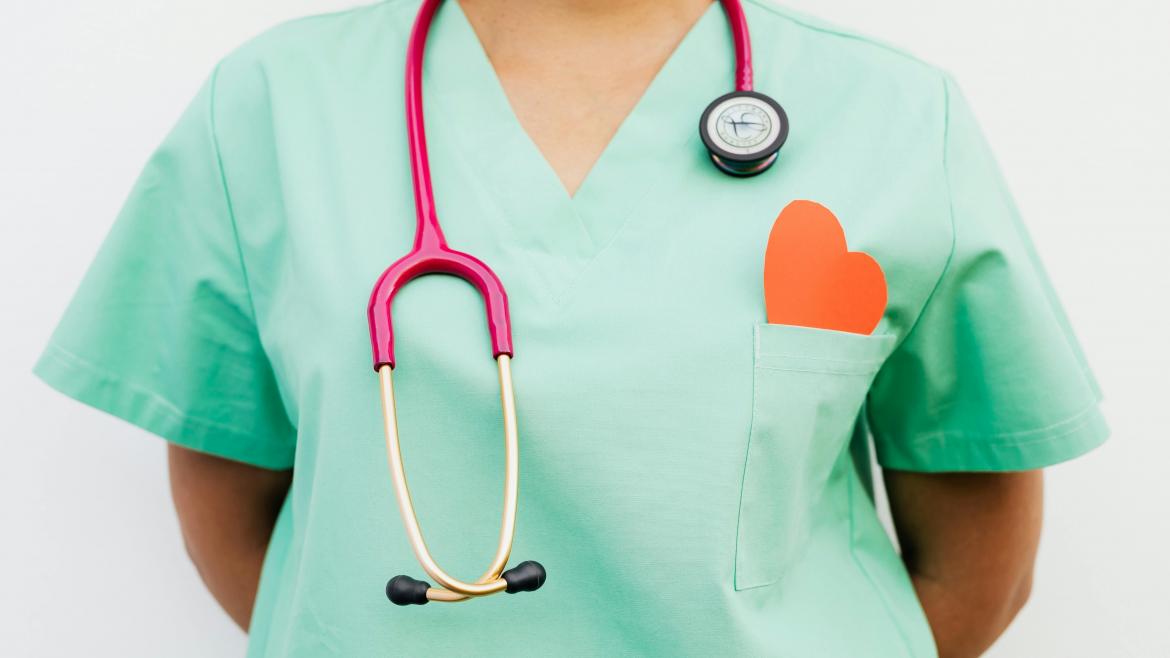 Médico con fonendoscopio y corazón en el bolsillo del uniforme sanitario