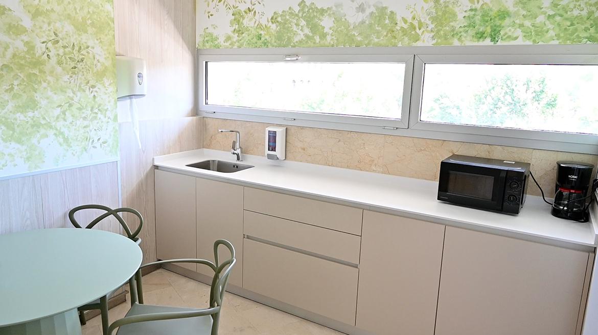 Sala para padres de la UCI pediátrica del hospital Sala equipada con un mesa y sillas y un office de cocina con nevera y microondas
