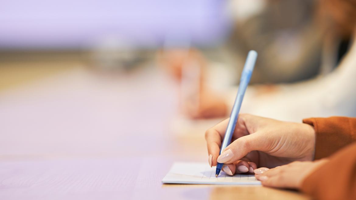 Las manos de una estudiante universitaria escribiendo