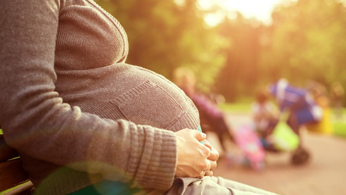 La Comunidad de Madrid aprueba una nueva inversión en ayudas a la maternidad de más de 114 millones de euros Una joven embarazada toca su barriga sentada en un parque