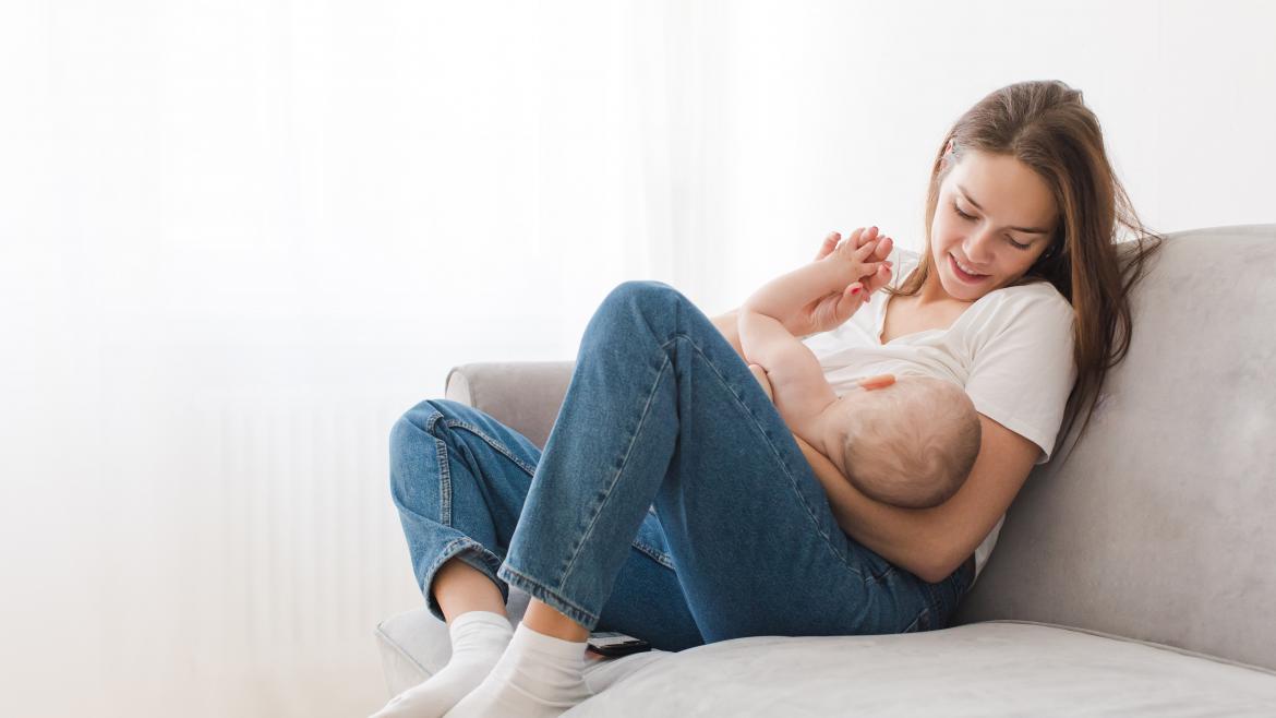 Madre sentada sillon con bebe