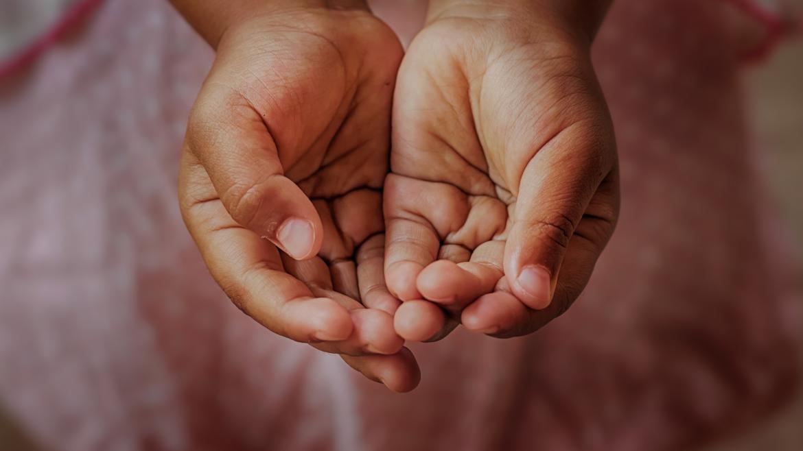Manos abiertas de niño pidiendo ayuda