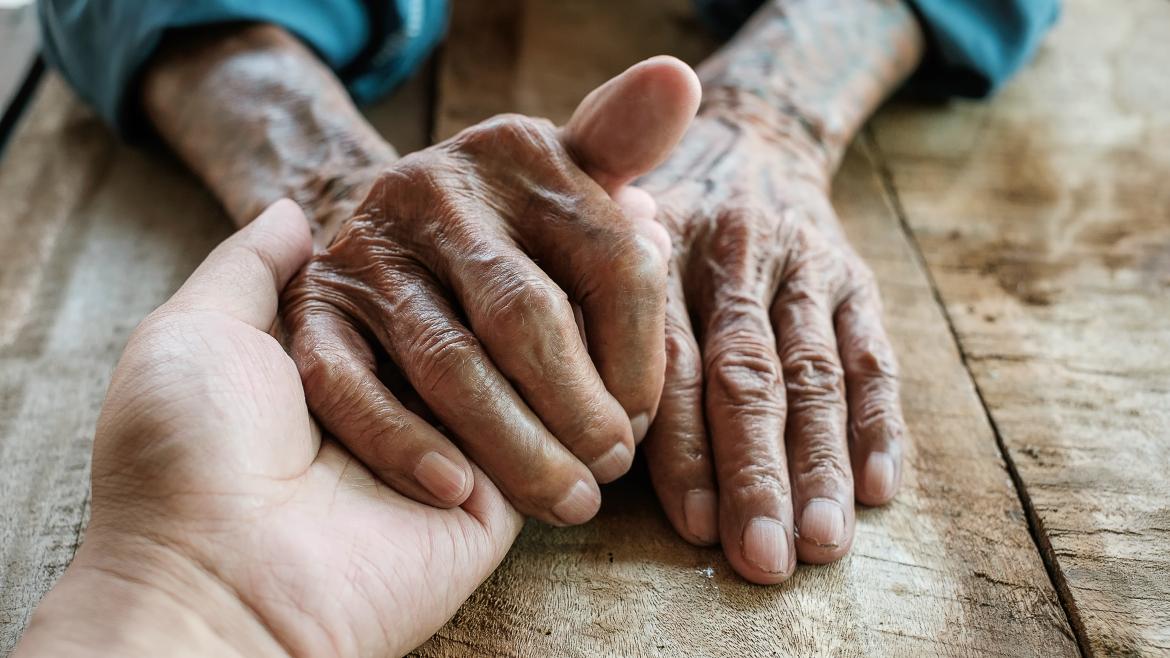 Un hombre coge las manos de otro mostrándole apoyo