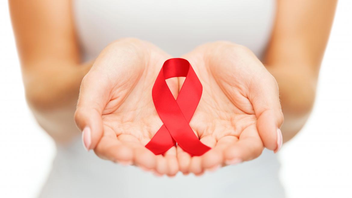 Mujer sostiene lazo rojo entre las manos