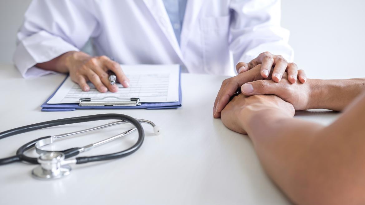 Médico sosteniendo la mano a un paciente