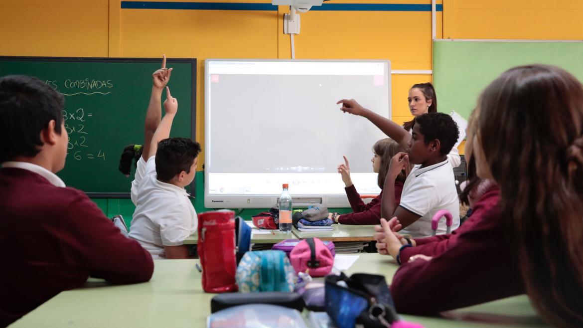 Estudiantes en clase preguntan a la profesora
