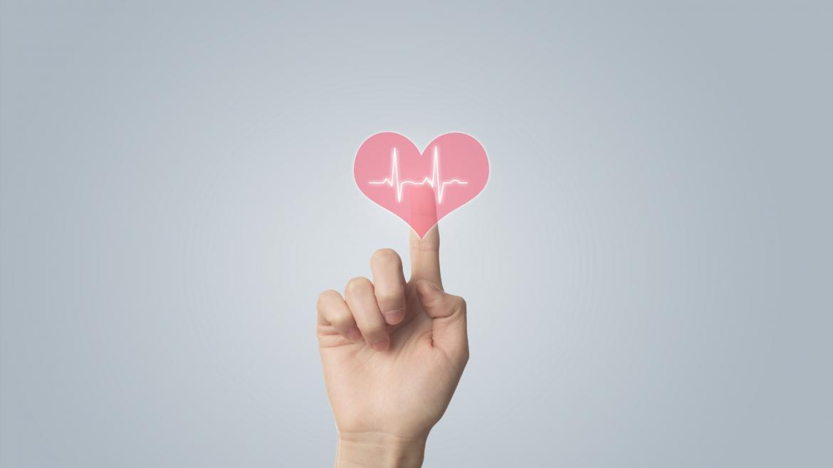 Otros recursos. Escuela Madrileña de Salud Mano pulsando un botón con forma de corazón y un gráfico de electrocardiograma dentro