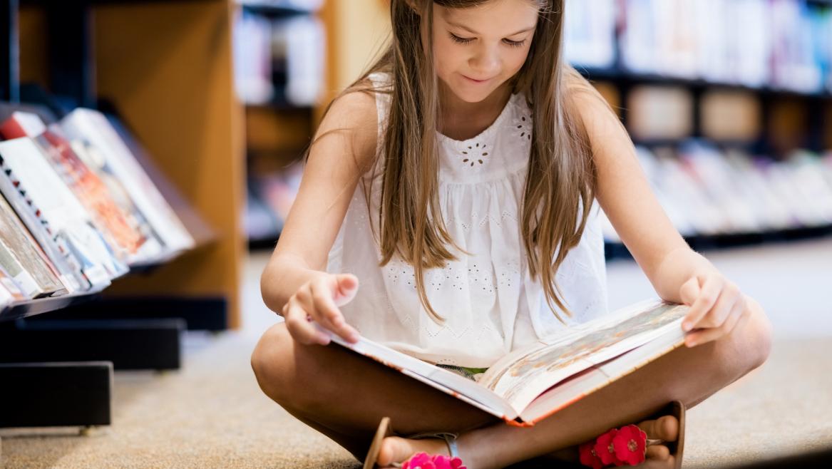 niña leyendo en una biblioteca