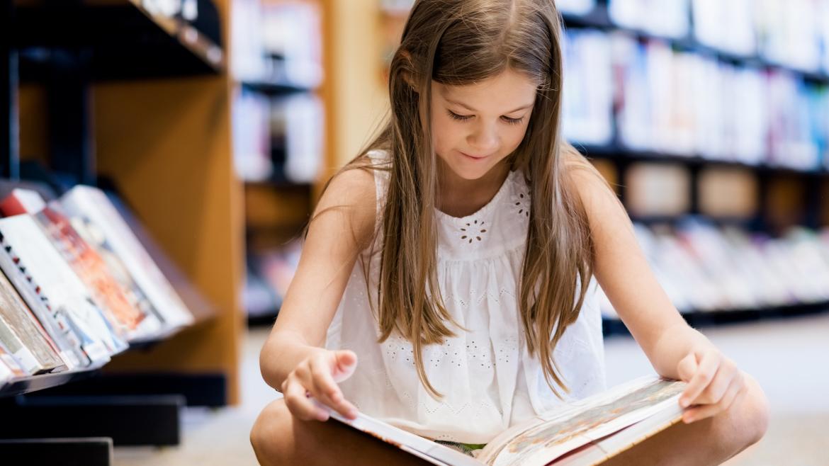 lectura infantil niña leyendo en una biblioteca