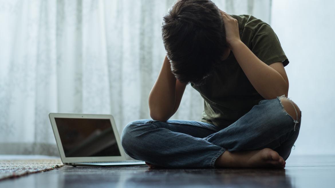 Ciberacoso en jóvenes Niño manos cabeza ordenador
