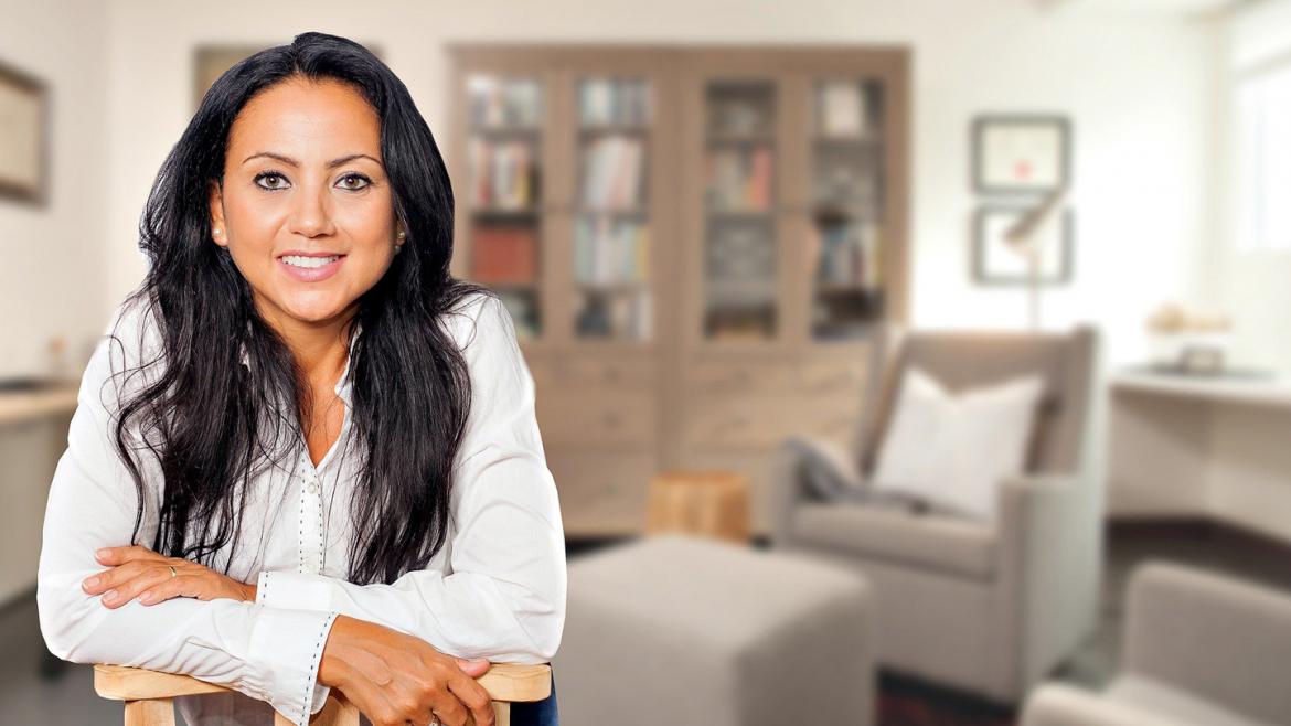 Mujer sonríe desde su vivienda