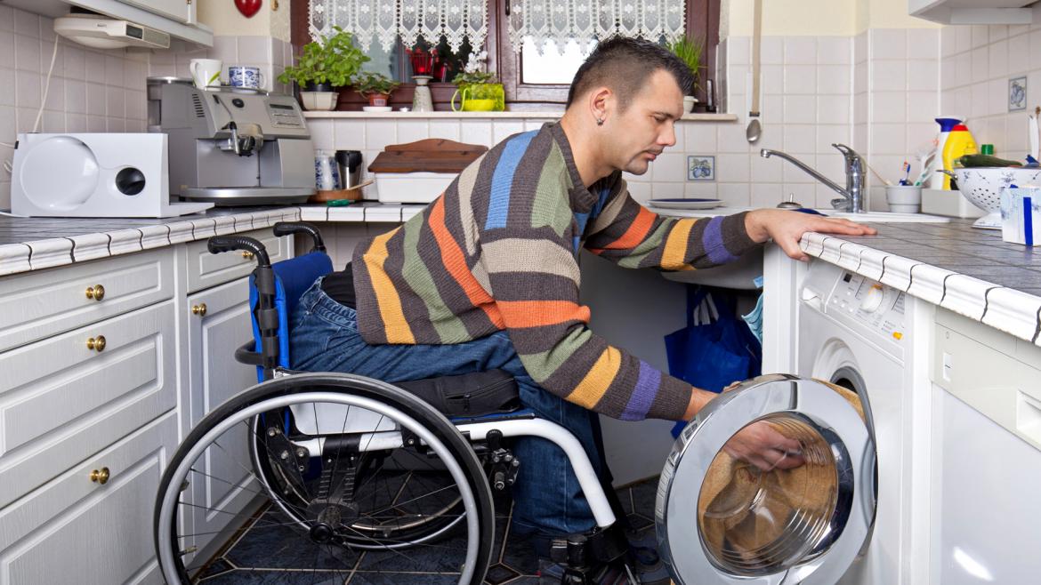 Recurso Servicio de Transición a la Vida Independiente Joven con discapacidad física poniendo la lavadora