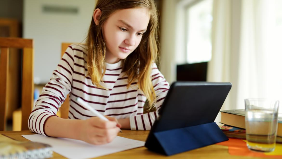 Niña haciendo los deberes en una tablet en casa