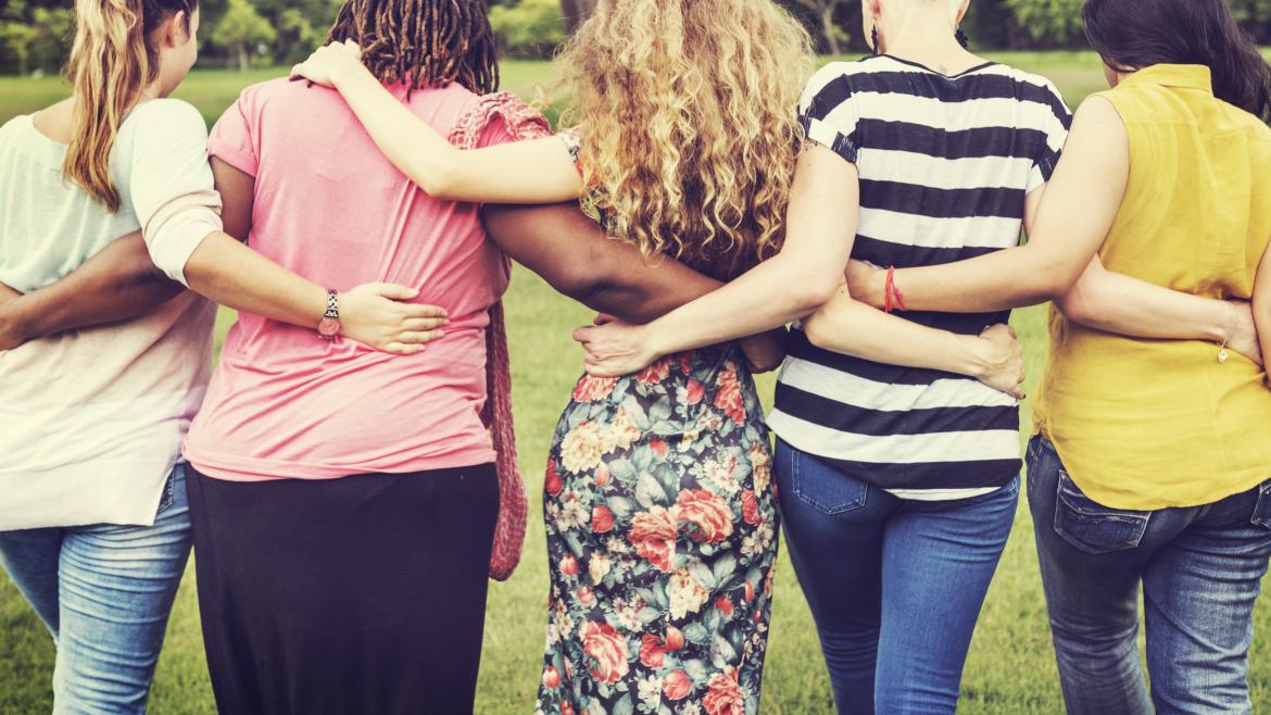 Varias mujeres de espaldas en línea abrazadas por la cintura
