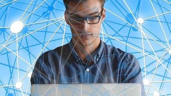 Joven con gafas delante de portatil