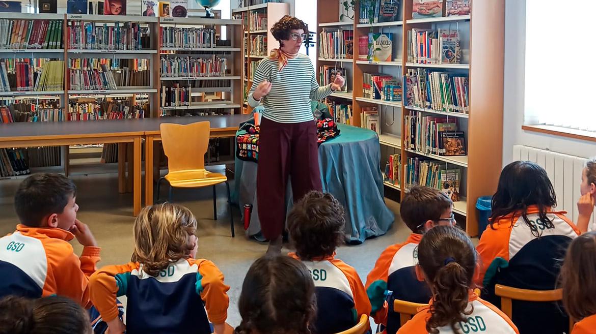 Mujer contando un cuento a un grupo de niños en una biblioteca