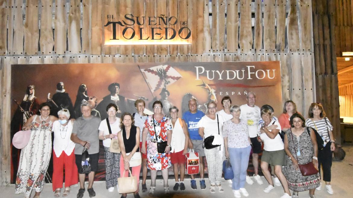 Ciudadanos delante del cartel de la representación de Puy Du Fou