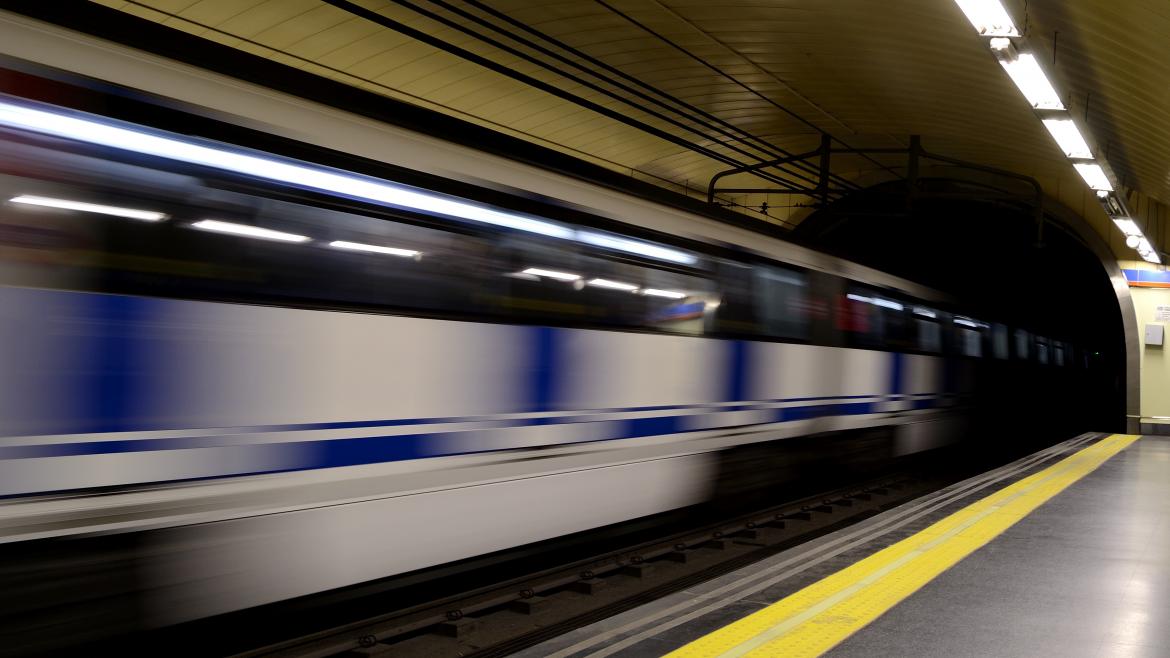 Un tren de Metro en movimiento al pasar por una estación