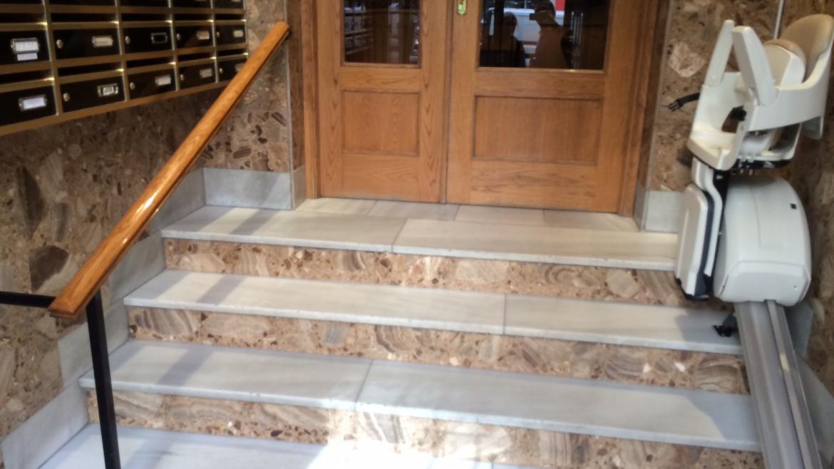 Imagen de silla salvaescaleras en la entrada de un bloque de pisos