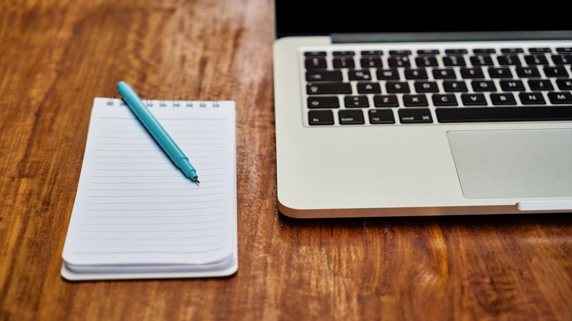 Un bloc para tomar notas junto a un ordenador portatil