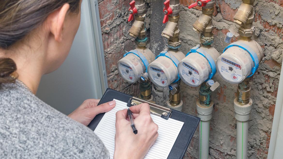 Una mujer midiendo un contador de agua