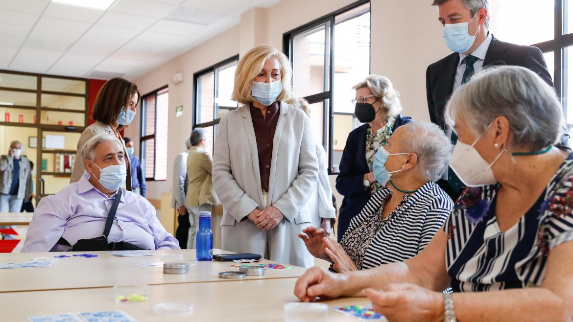 La consejera hablando con personas mayores sentadas en una mesa