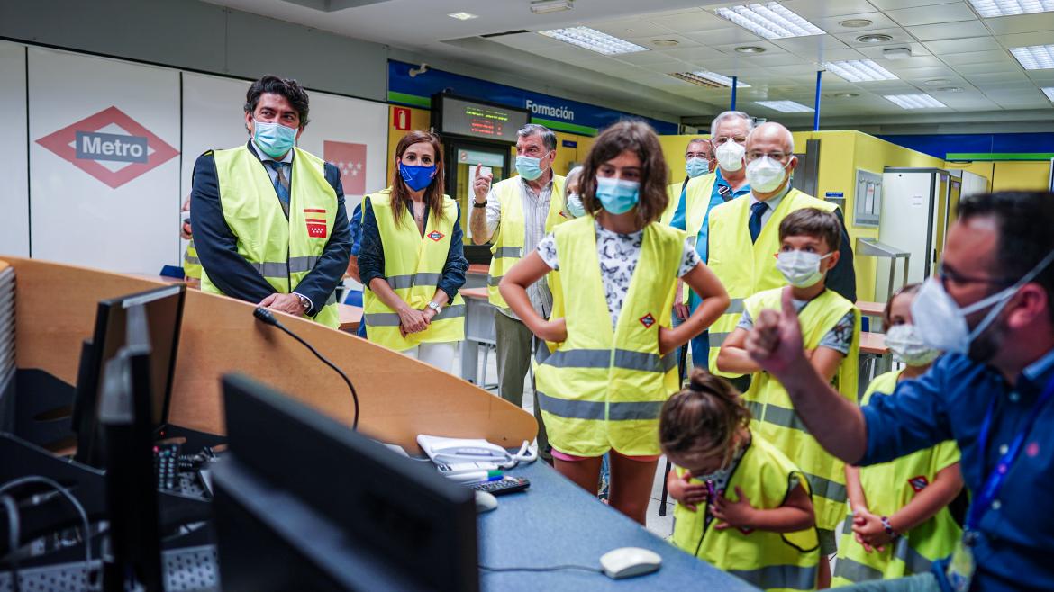 El consejero junto a un grupo de niños y abuelos escuchando las explicaciones de un trabajador de metro