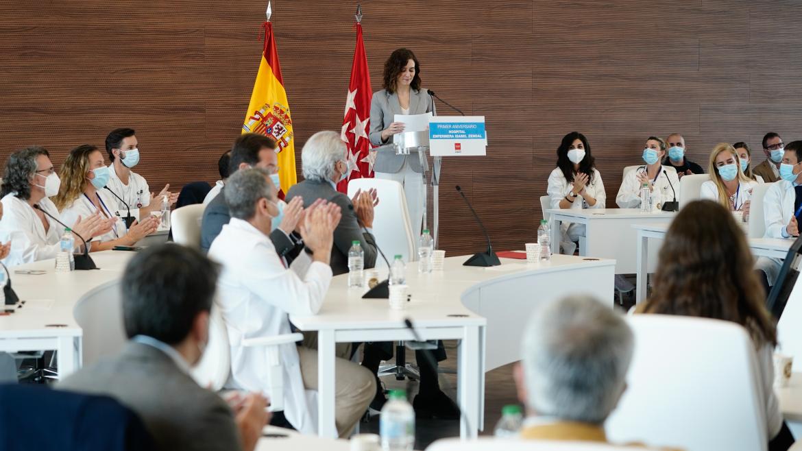 La presidenta interviniendo en el atril del auditorio rodeada por personal sanitario