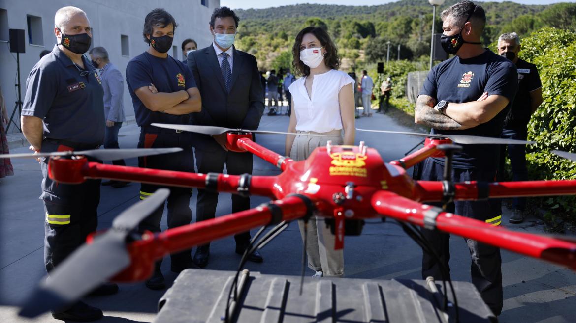 Isabel Díaz Ayuso visita el Parque de Bomberos de San Martín de Valdeiglesias La presidenta con algunos bomberos mirando un dron
