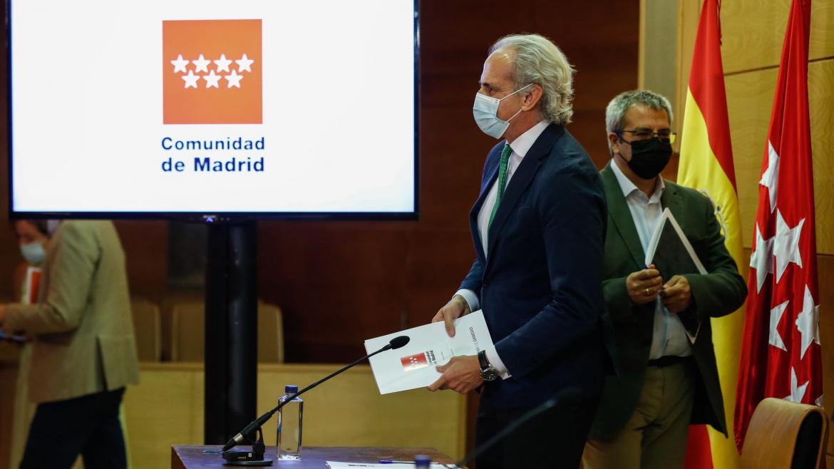 Ruíz Escudero ante la mesa de la rueda de prensa con cartel detrás de la Comunidad de Madrid