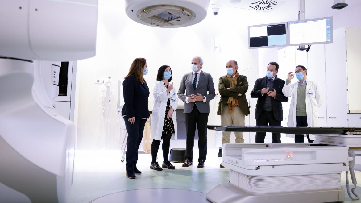 El consejero junto a otros asistentes a la visita contemplando una de las máquinas