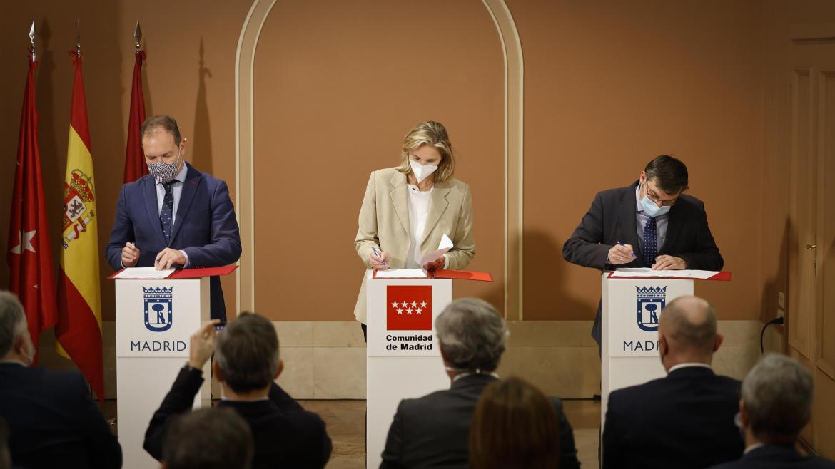 La consejera junto a las otros otros dos representantes firmando el convenio